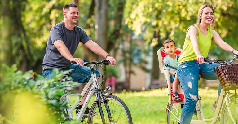 Casal com criança andando de bicicleta